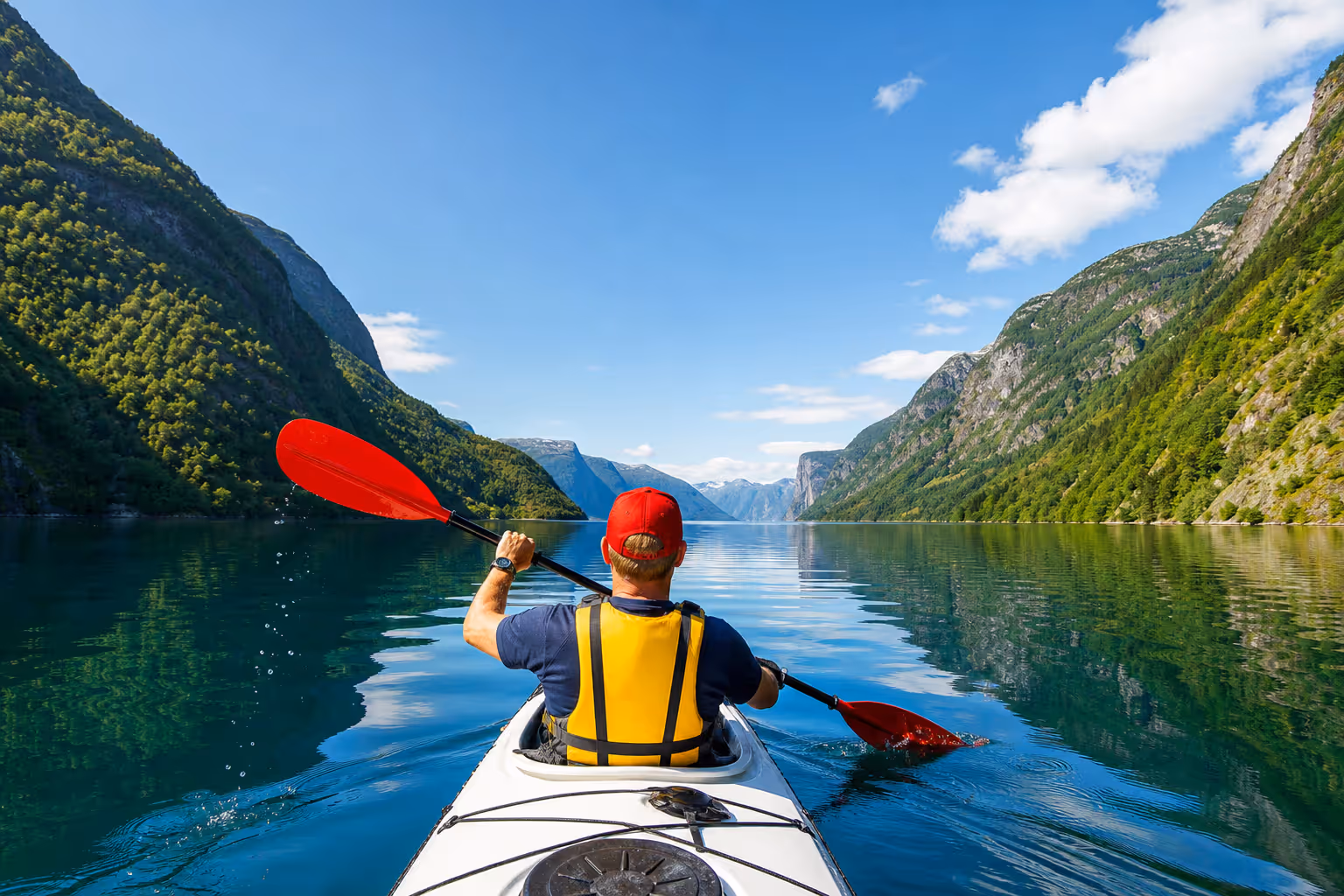 Kajakfahrer auf einem Bergsee zwischen steilen Ufern — Paddeln mit Weitblick
